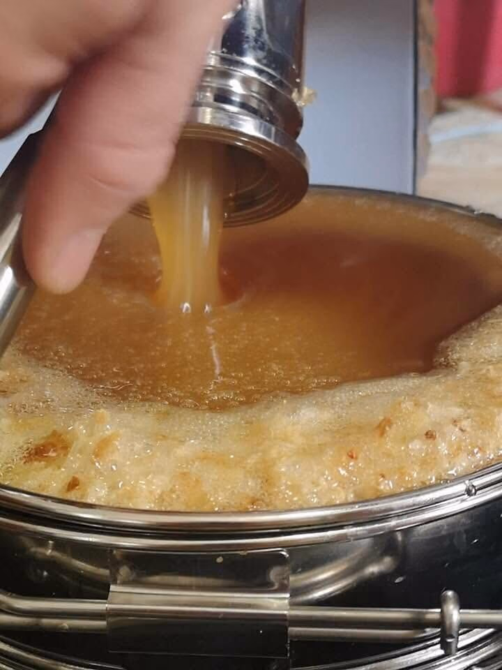 Miele versato in un vasetto durante la smielatura a freddo